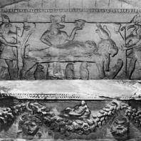 Александрия Египетская. Ком эшь-Шукафа. Ниша в погребальной камере. На переднем плане саркофаг, украшенный гирляндами и масками, в глубине на стене - рельеф с изображением сцены мумификации, совершаемой Анубисом. С правой стороны бог Тот, с левой - Гор. Конец I в.н.э.