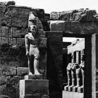Карнак. Египет. Храм Амона. Вход в храм Рамсеса III из первого двора. На переднем плане статуя этого фараона. Фотограф: Анджей Дзевановский